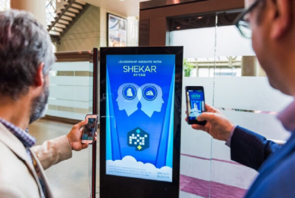 Marquee Event Support thumbnail, two men scanning a poster with their phones at a trade show